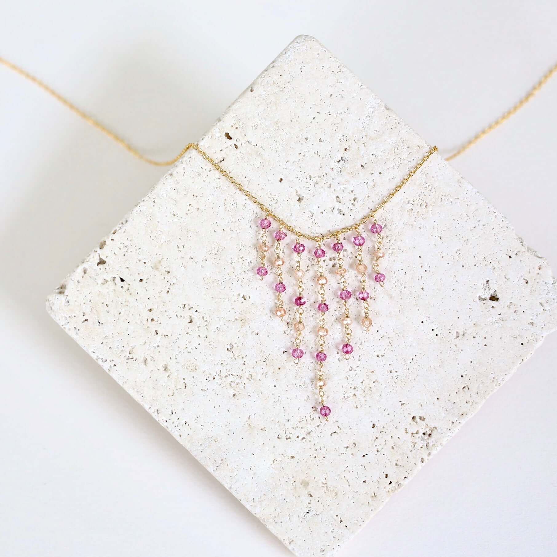Necklace with pink beads on a textured white surface