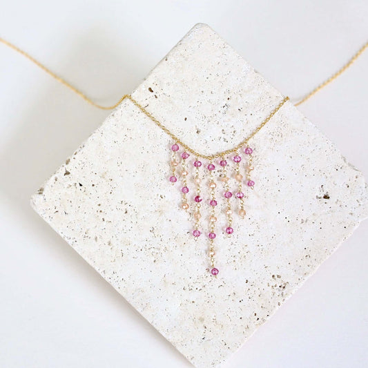 Necklace with pink beads on a textured white surface