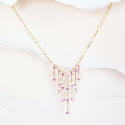 Necklace with pink beads on a mannequin bust against a white background