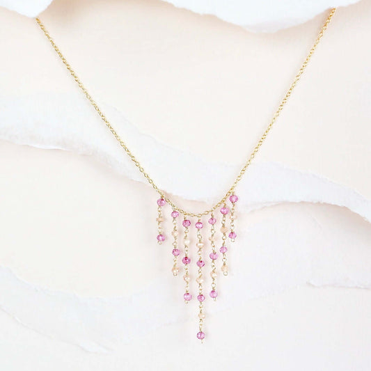 Necklace with pink beads on a mannequin bust against a white background