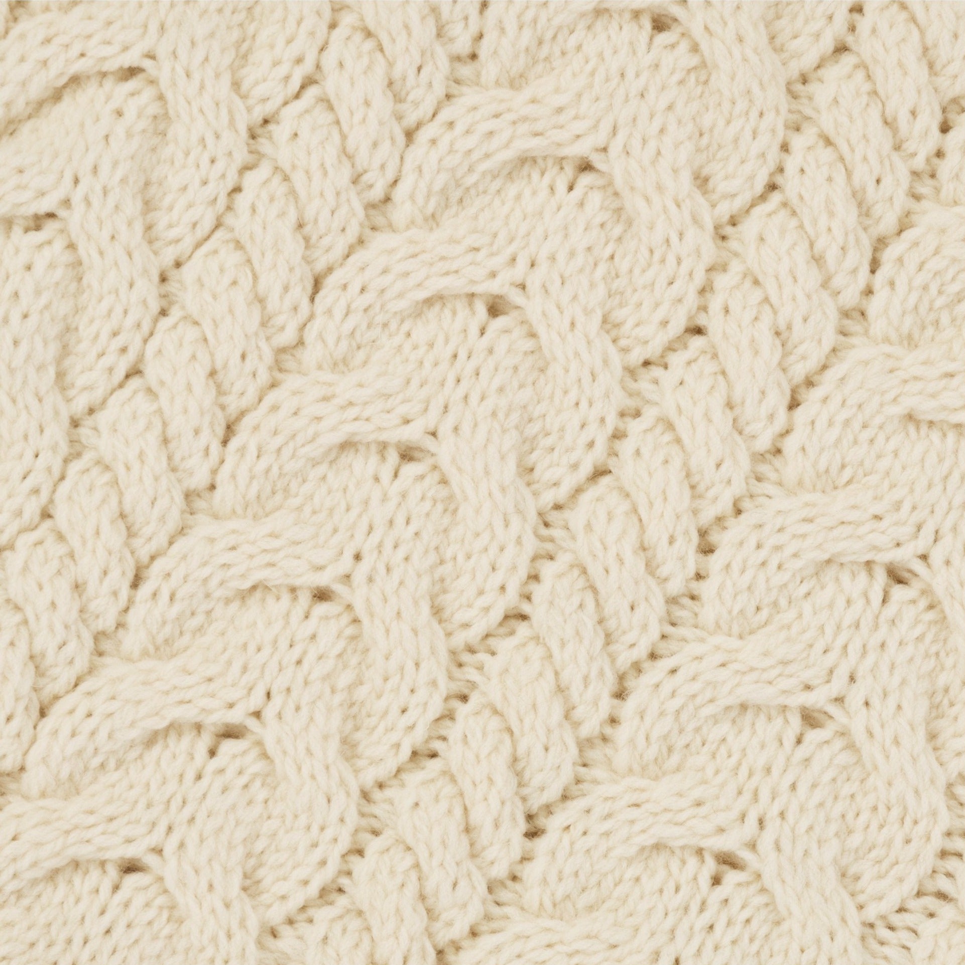 Close-up of a textured beige fabric with a cable knit pattern