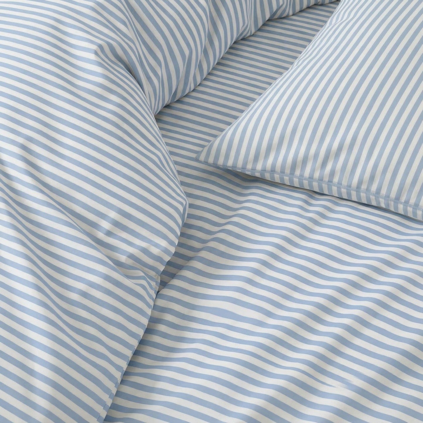 Close-up of blue and white striped bedding with pillows.