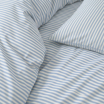 Close-up of blue and white striped bedding with pillows.