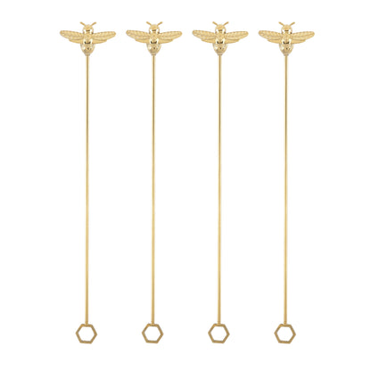 Set of four gold bumble bee stir sticks with hexagonal ends on a white background.