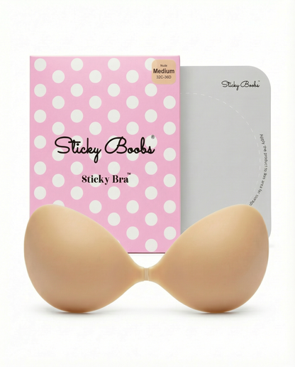 Beige Sticky Boobs adhesive bra in Medium with pink polka-dot packaging and protective storage board.