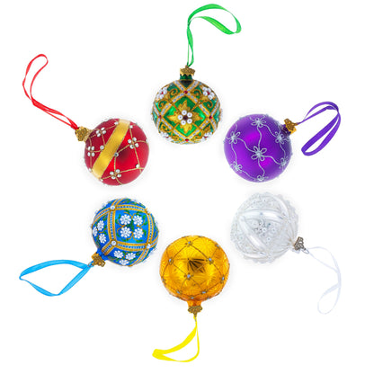 Six multicolored glass ball ornaments with intricate bead and glitter patterns arranged in a circle on a white background.