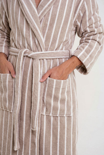 Person wearing a beige and white striped robe with a white background