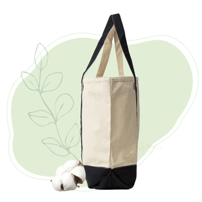 Beige and black tote bag with cotton plant on a light green background