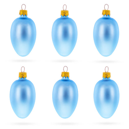 Six light blue matte glass egg ornaments with gold caps arranged in two rows of three on a white background.