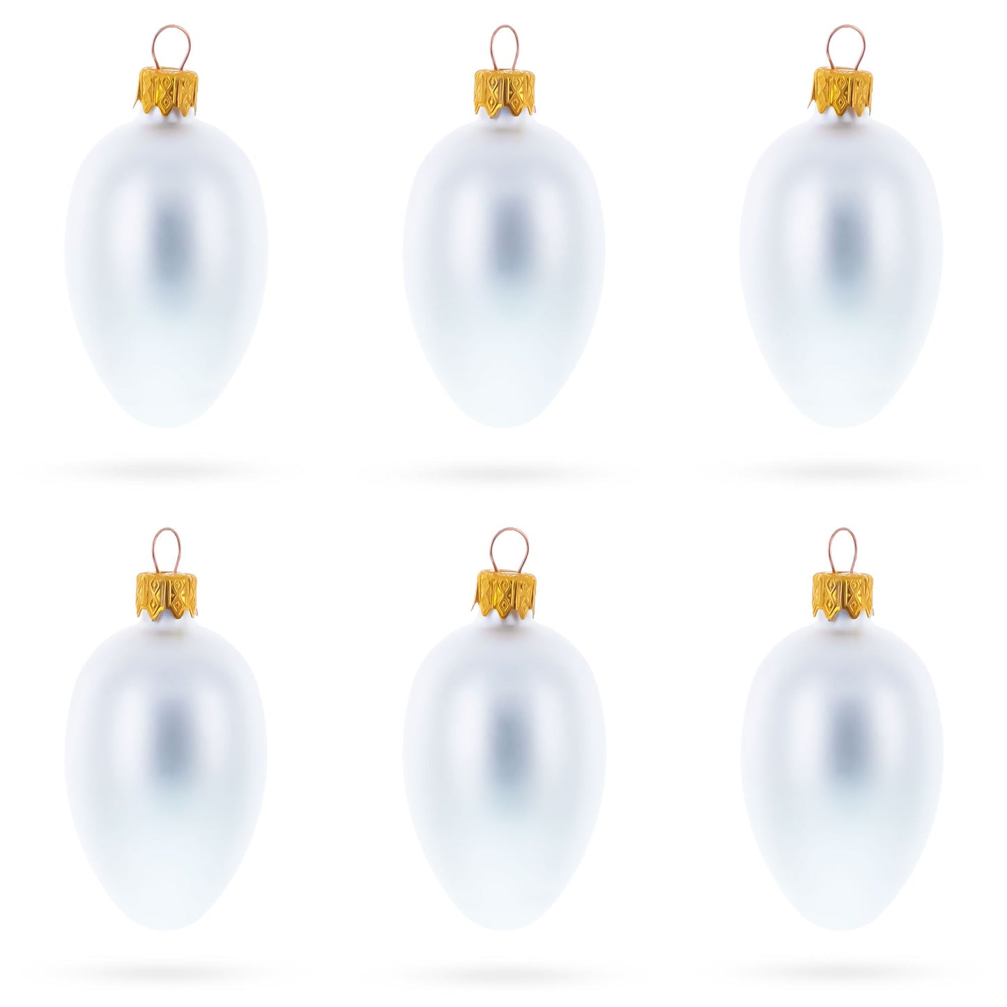 Six matte white glass egg ornaments with gold caps arranged in two rows of three on a white background.