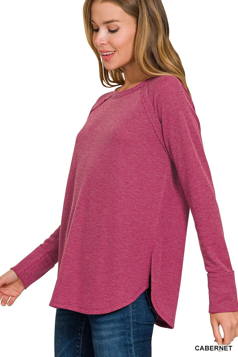 Woman wearing a pink long-sleeve top on a white background