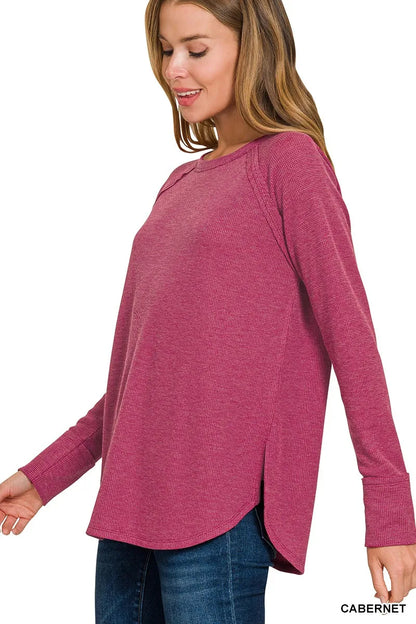 Woman wearing a pink long-sleeve top on a white background