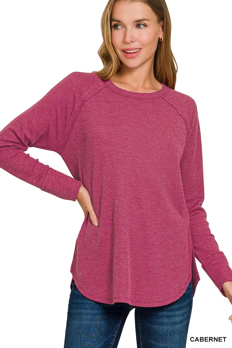 Woman wearing a pink long-sleeve top with 'Cabernet' text on a white background
