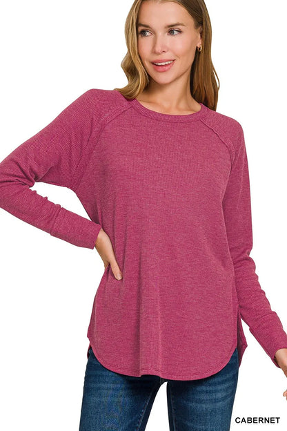 Woman wearing a pink long-sleeve top with 'Cabernet' text on a white background