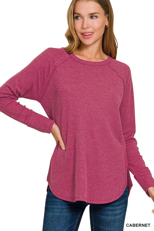 Woman wearing a pink long-sleeve top with 'Cabernet' text on a white background