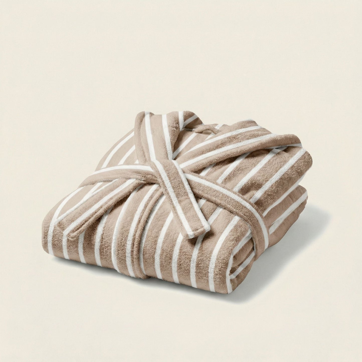 Folded beige and white striped towel on a light beige background