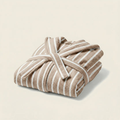 Folded beige and white striped towel on a light beige background