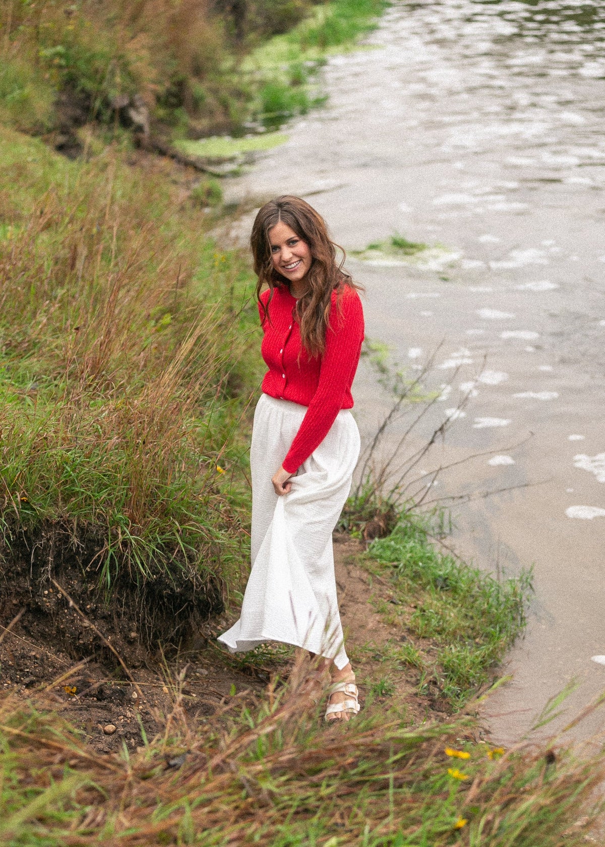 Woman wearing the Mason red cable knit button up cardigan with a flowy skirt