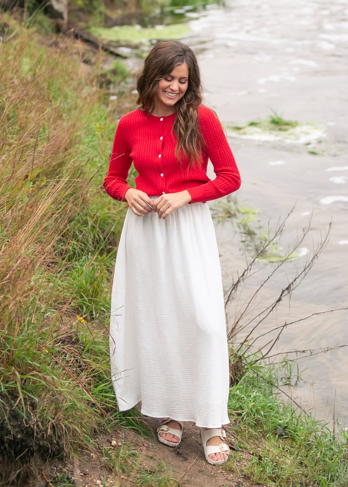 Woman wearing the Mason red cable knit button up cardigan with a flowy skirt