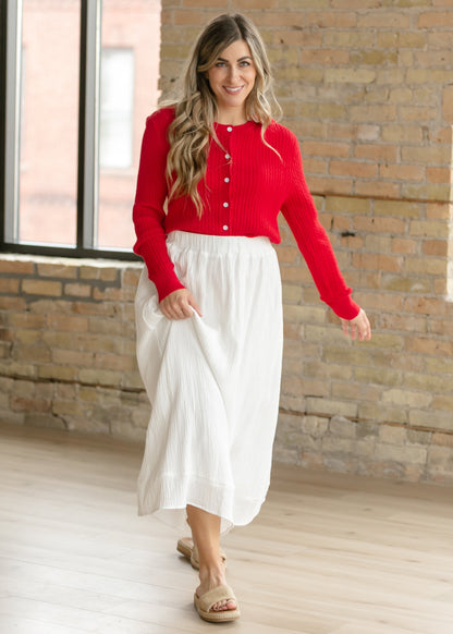 Woman wearing the Mason red cable knit button up cardigan with a flowy skirt