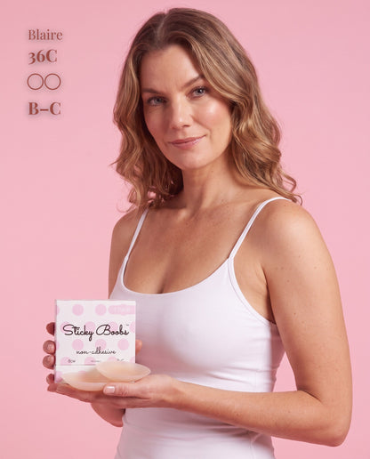 Model in a white camisole holding Light nipple covers and B–C packaging, with a 36C size label.