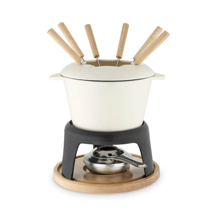White fondue pot with wooden skewers on a black burner with a wooden base on a white background