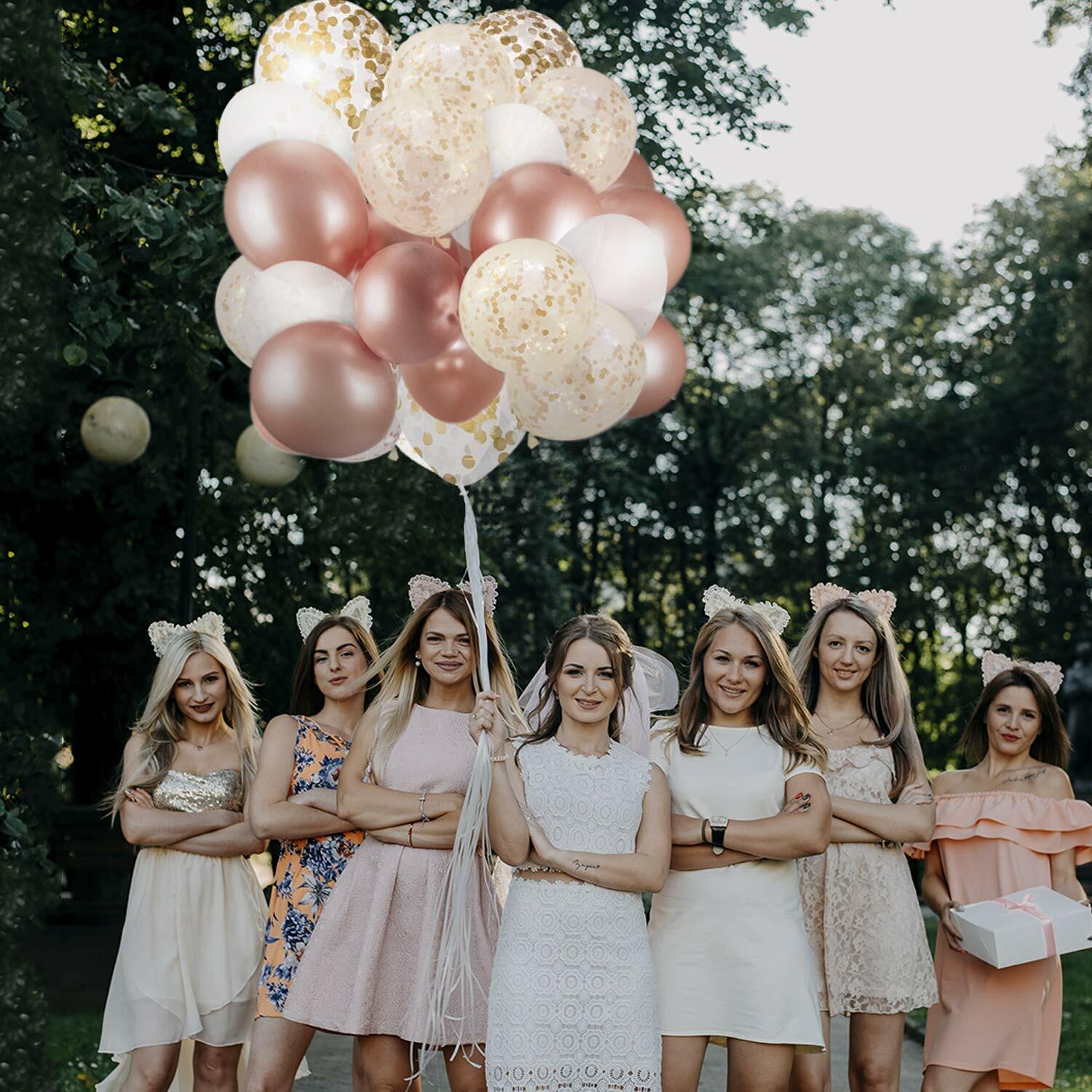 Dandy Decor 60 pack of 12-inch rose gold and white confetti balloons held by a group of women outdoors.
