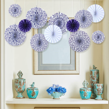 Chinoiserie hanging paper fans in blue and white, arranged decoratively above a shelf with vases and flowers.