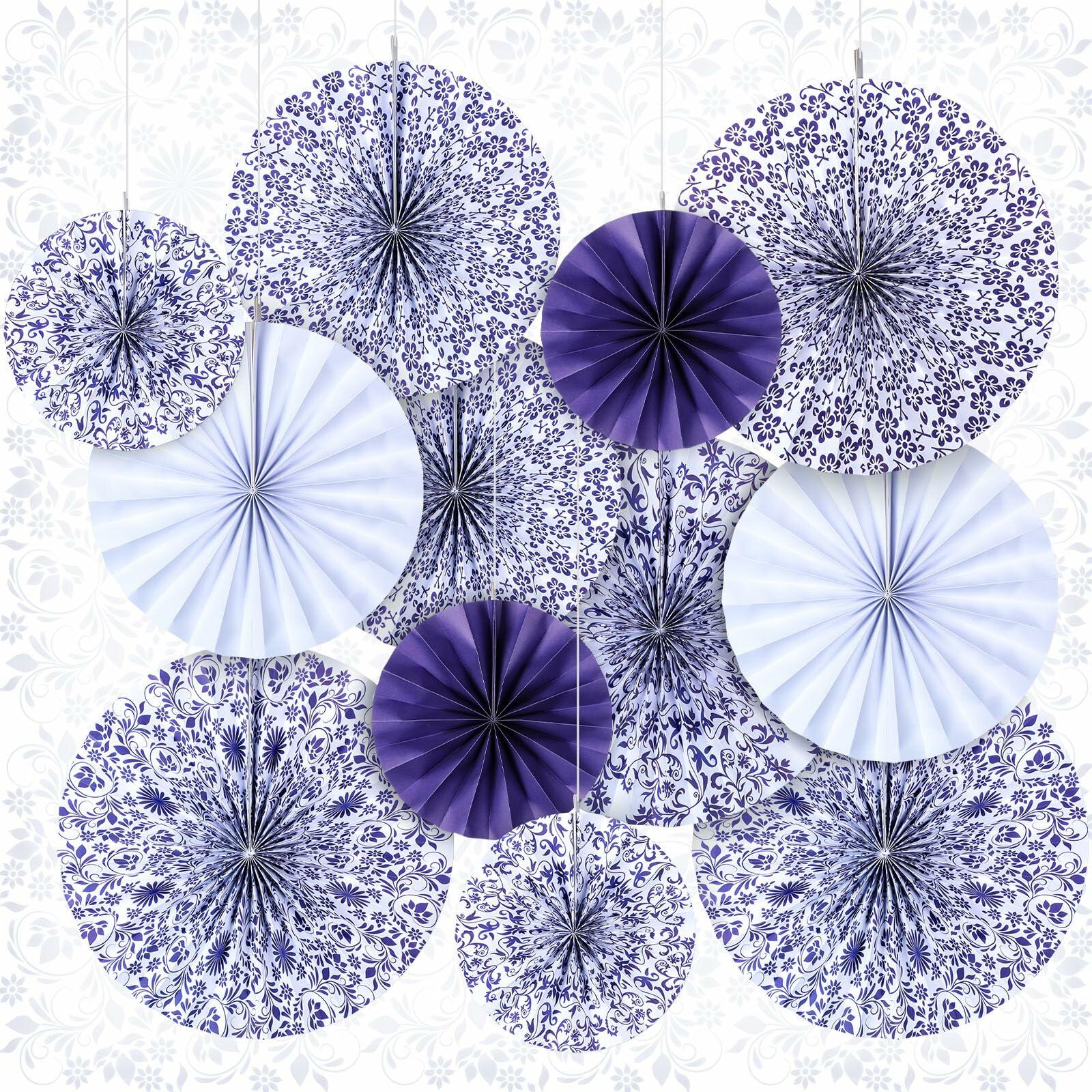 Chinoiserie hanging paper fans in blue and white, featuring floral and geometric patterns, arranged in a decorative display.