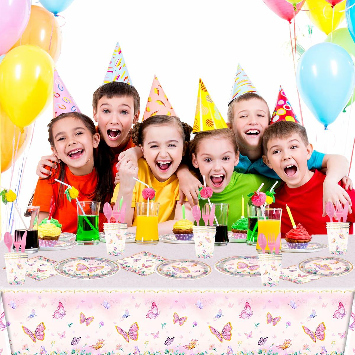 Colorful pink butterfly party tableware set with plates, napkins, and a tablecloth, displayed at a festive children's party.