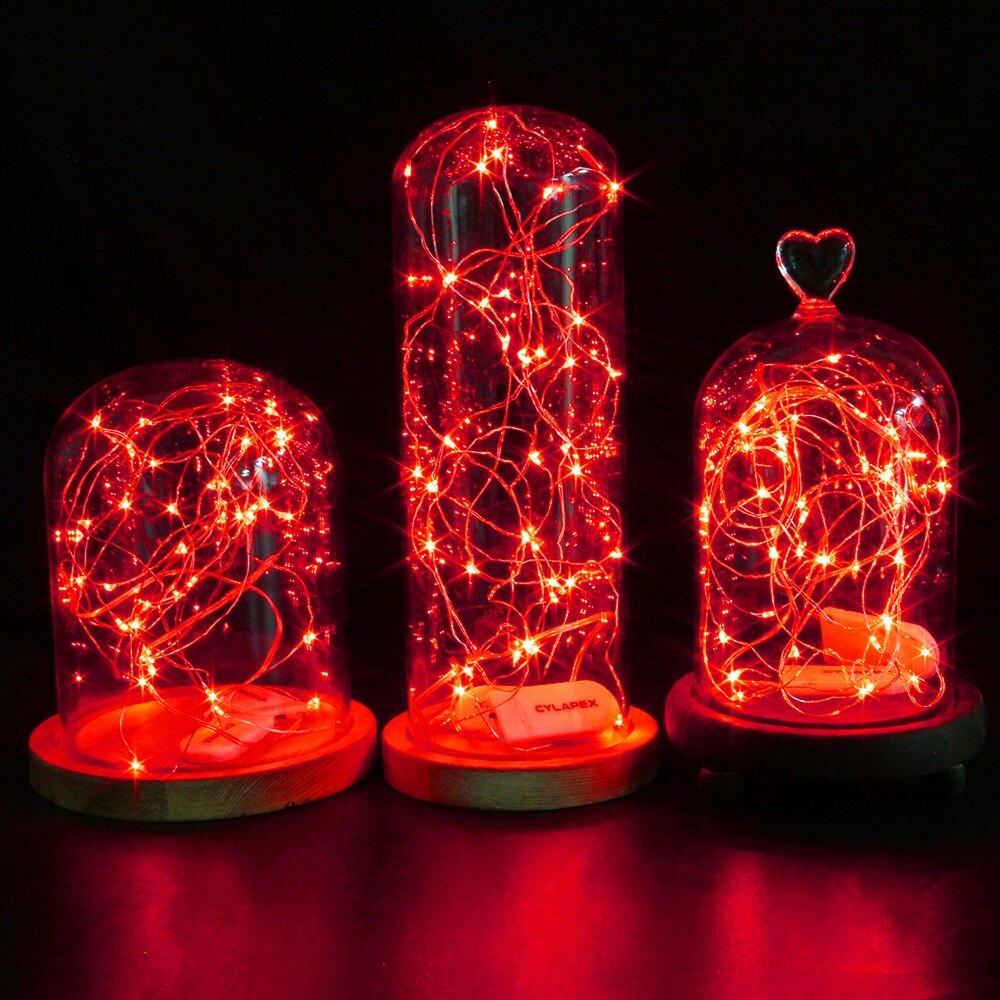 Three decorative lights with red LED strings inside glass domes on a black background