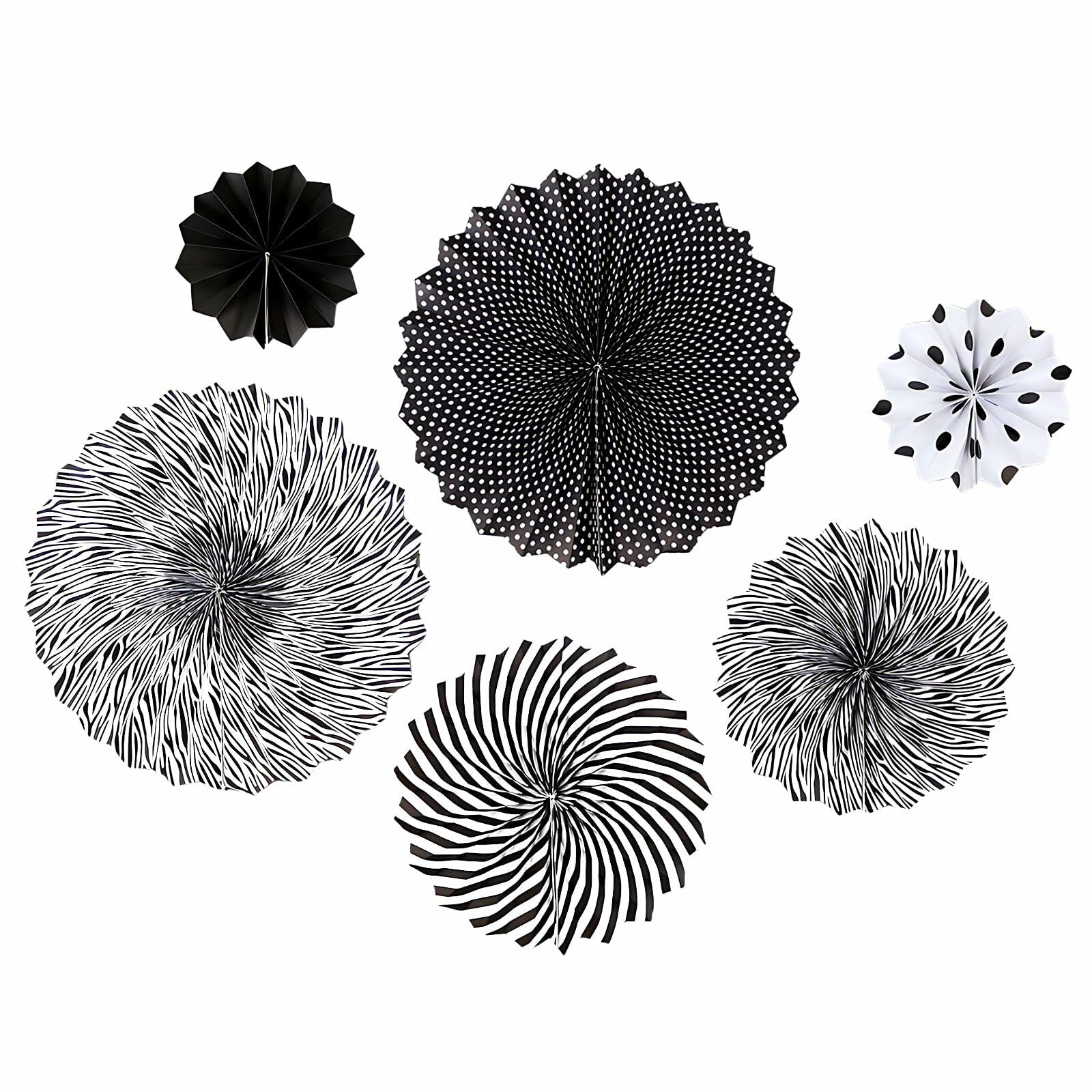 Black hanging paper fans in various designs, including stripes and polka dots, arranged in a circular pattern.