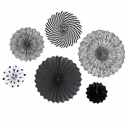 Black hanging paper fans in various sizes and patterns, including stripes, polka dots, and floral designs.