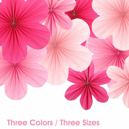 Pink paper fans and flowers in various sizes, featuring shades of pink and white, arranged for party decoration.