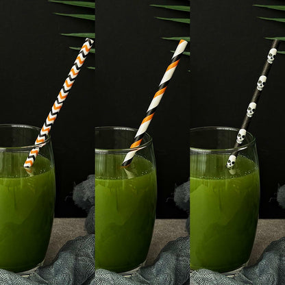 Halloween paper straws in mixed styles, featuring orange and black patterns, displayed in glasses with green drinks.