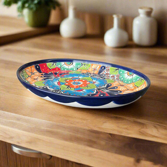Colorful ceramic plate on a wooden surface with decorative vases in the background.