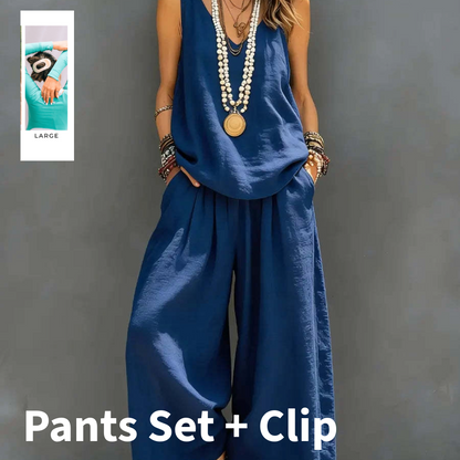 Person wearing a blue pants set with a clip on a gray background