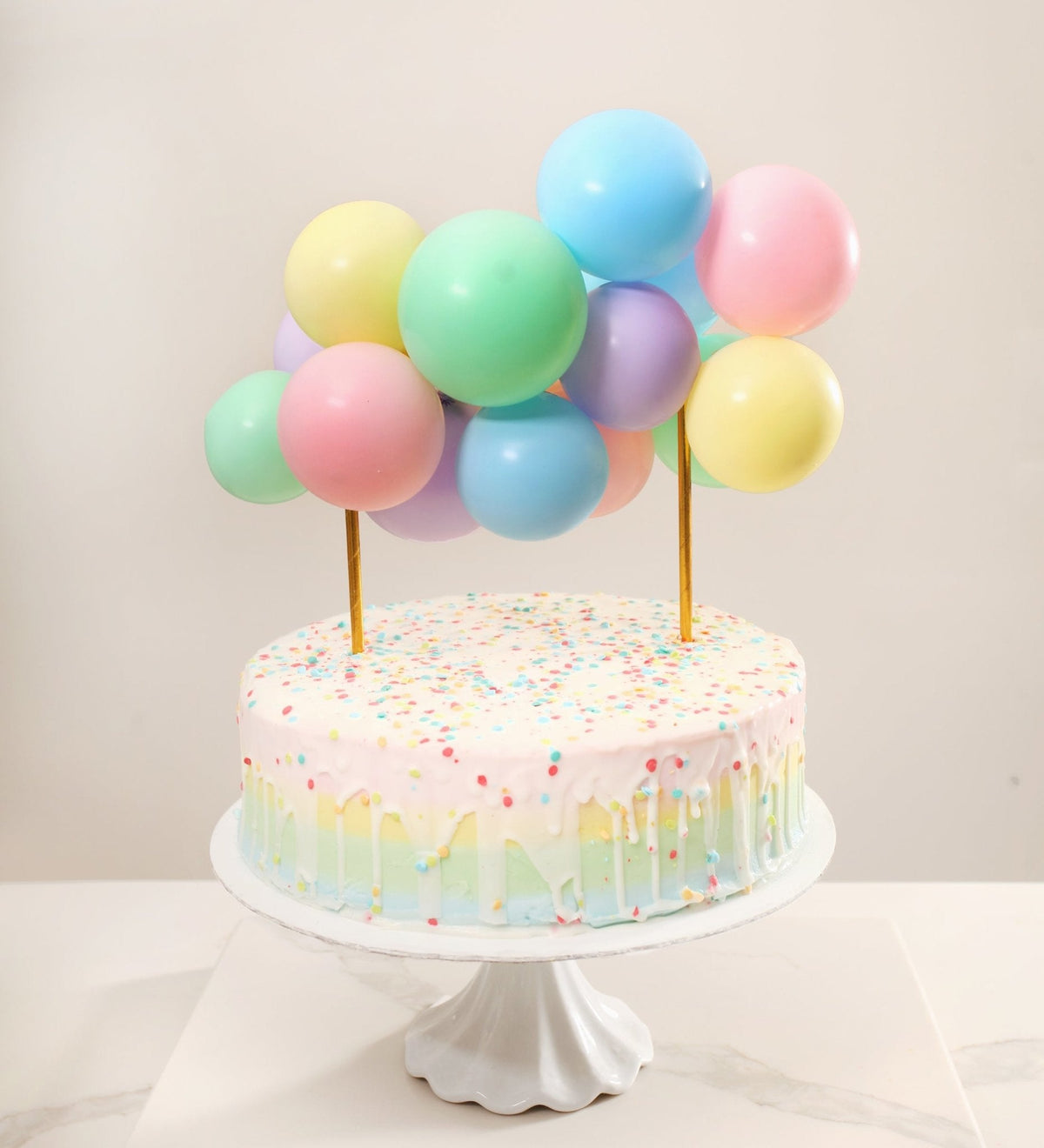Cake with colorful balloons on a white background