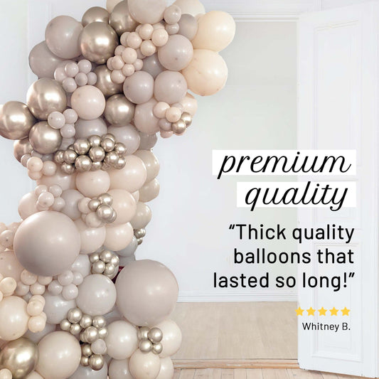 A balloon garland arch in champagne, beige, and metallic silver tones displayed in a bright room, with promotional text on the right reading 'premium quality' and a customer review by Whitney B.