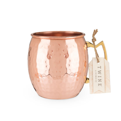 Hammered copper Moscow mule mug with a Twine Living tag tied to its gold-tone handle.