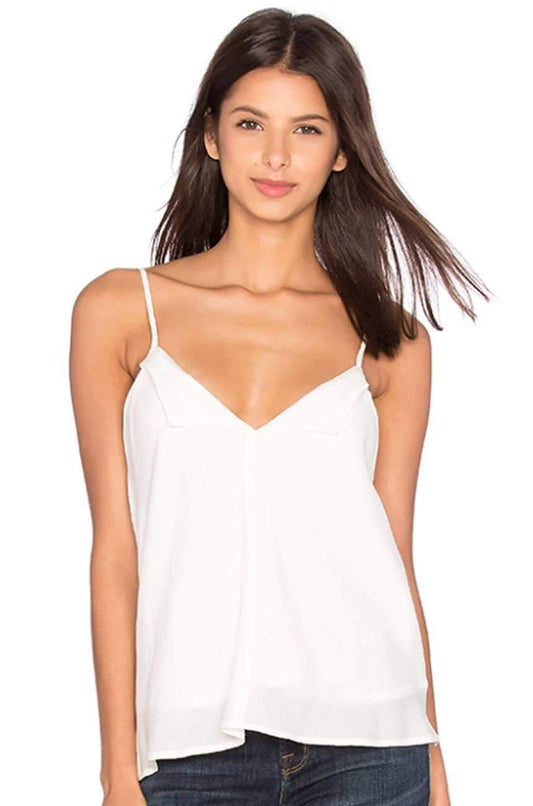 A woman wearing a white spaghetti-strap camisole top and dark blue jeans, photographed against a plain white background.