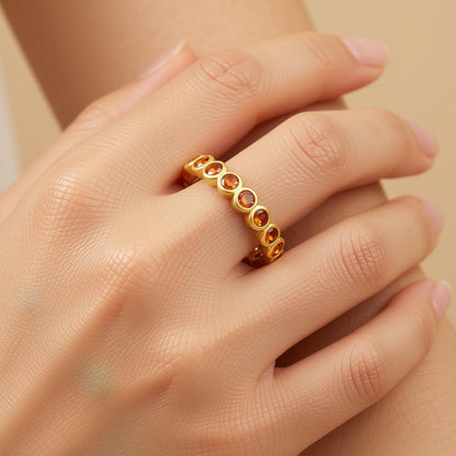 Orange CZ eternity ring on a woman's finger.