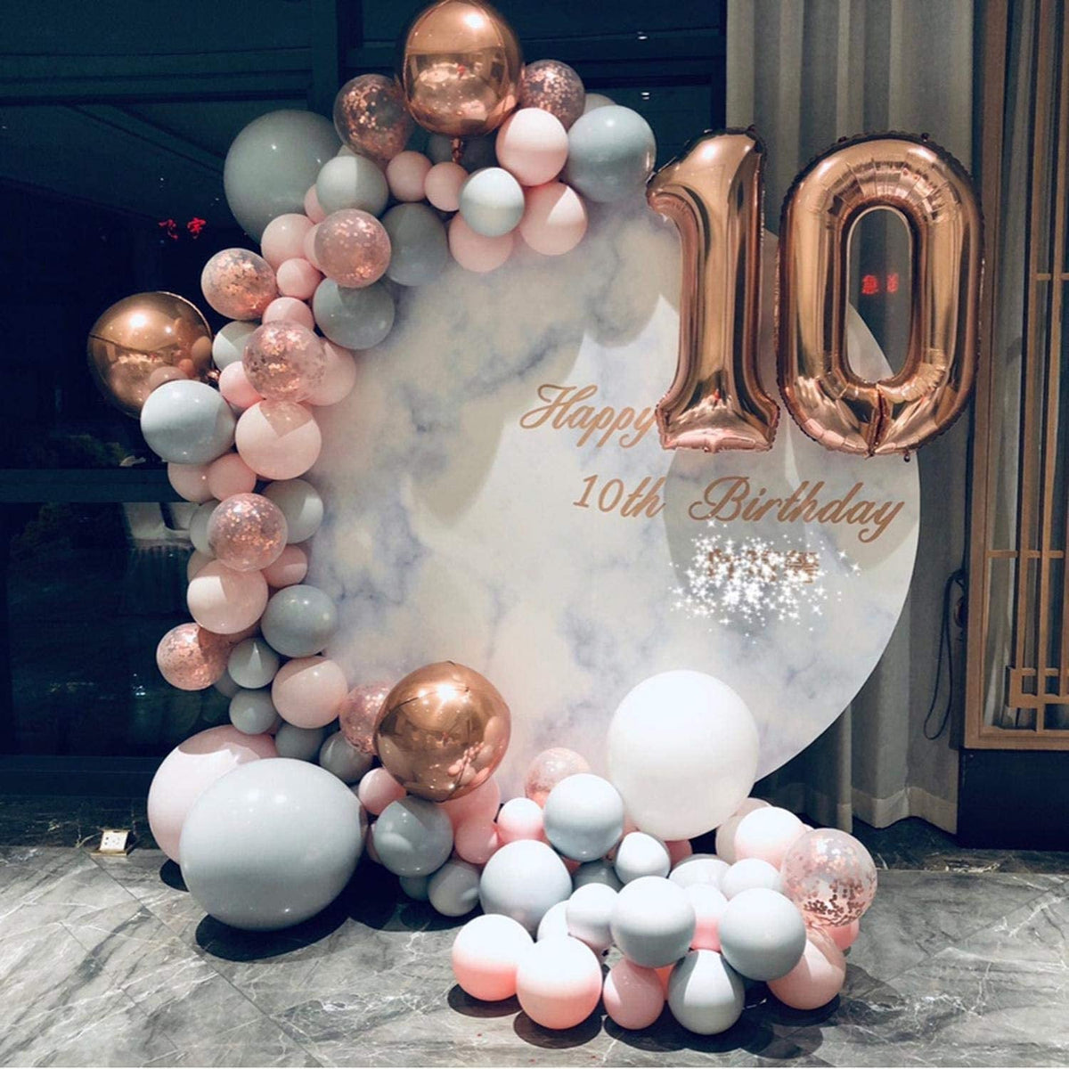 Balloon arch with 'Happy 10th Birthday' text and rose gold, pink, and white balloons.