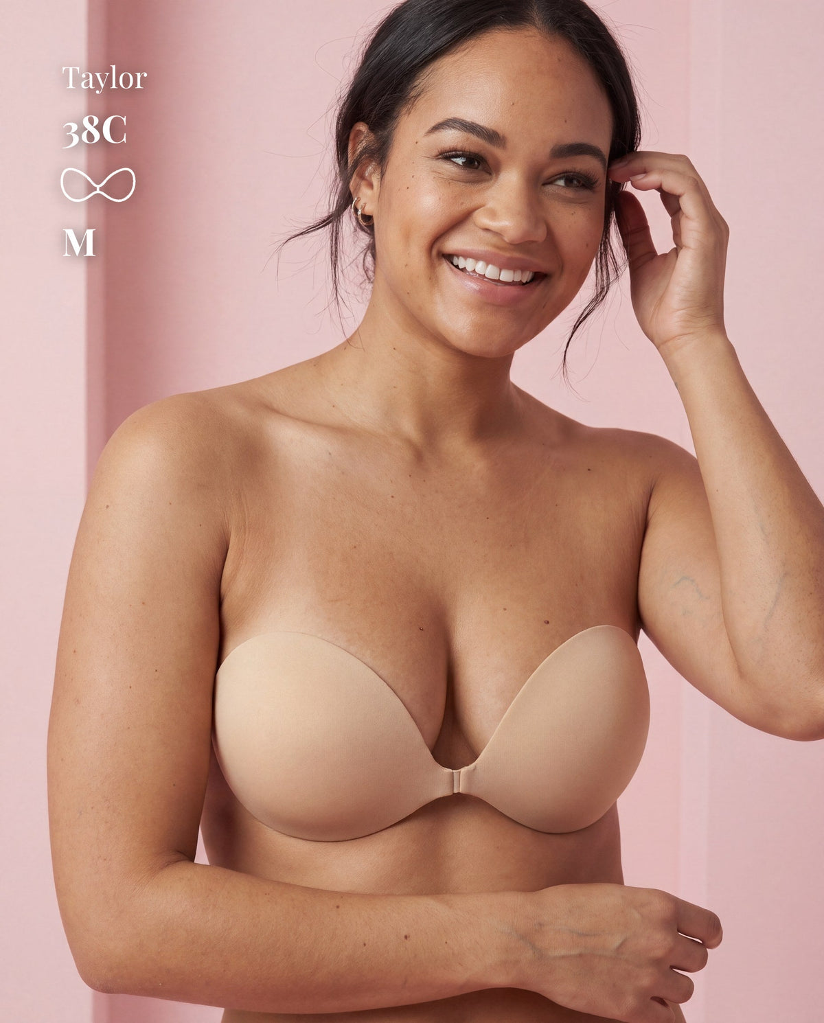 Front view of a model wearing the beige Sticky Bra in Medium, with a 38C size label.