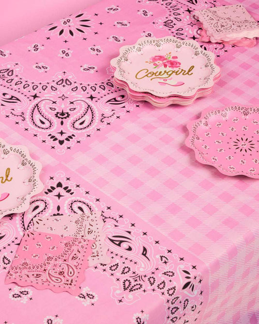 Pink tablecloth with paisley patterns and 'Cowgirl' themed paper plates.