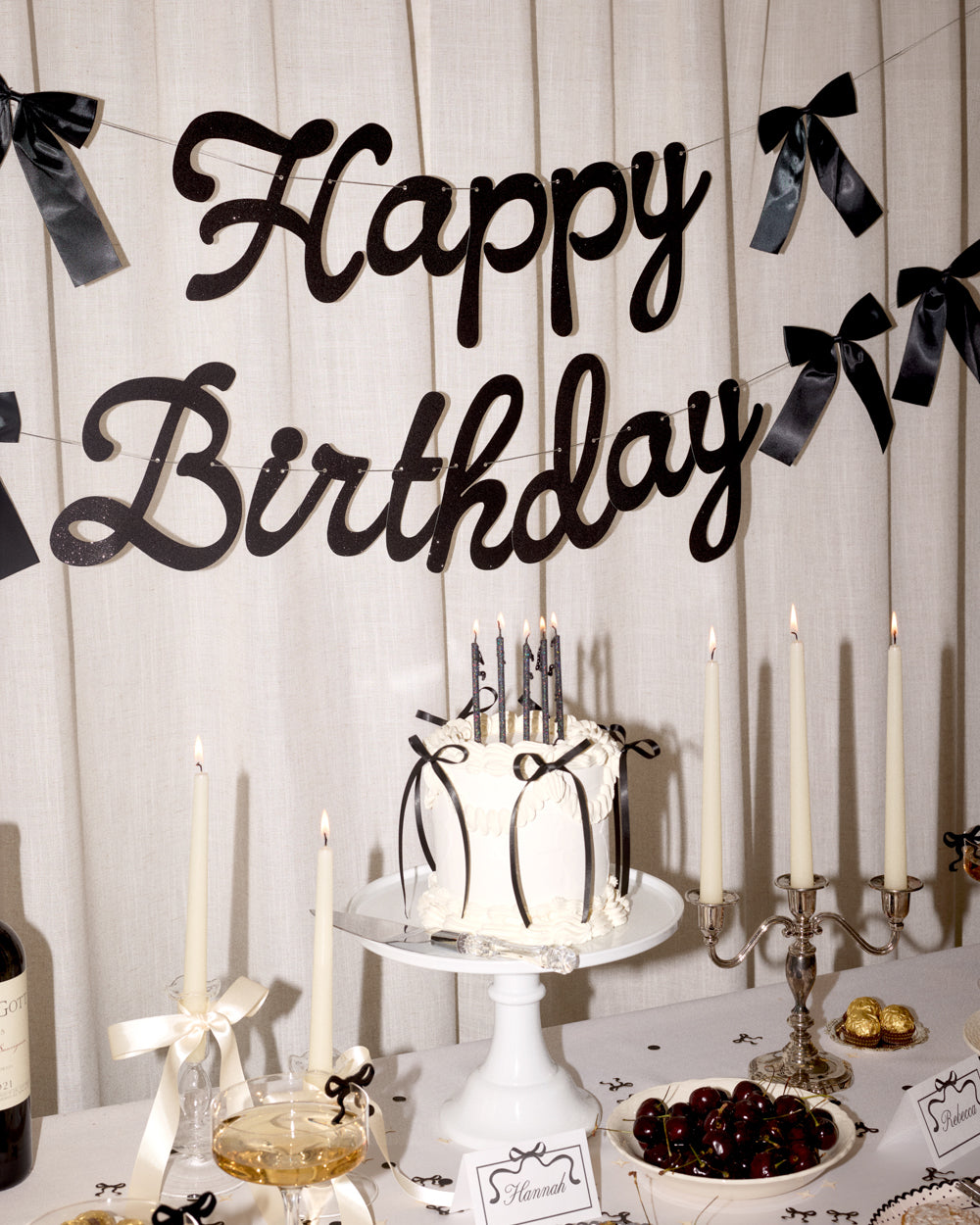 Birthday celebration setup with cake, candles, and 'Happy Birthday' banner.
