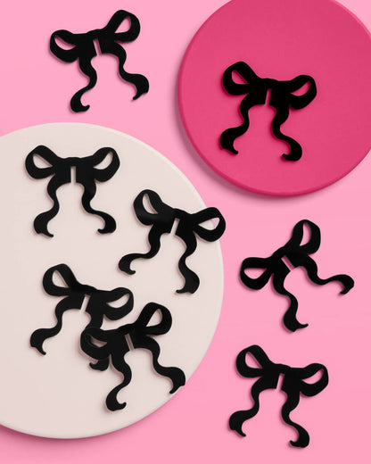 Black bow-shaped objects on a pink background