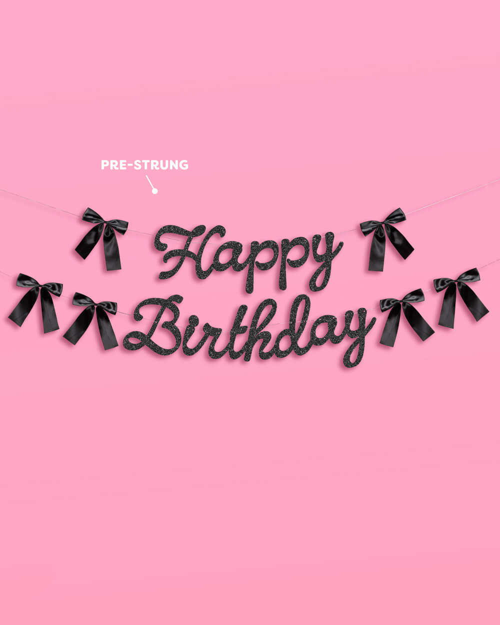 Black 'Happy Birthday' banner with ribbons on a pink background