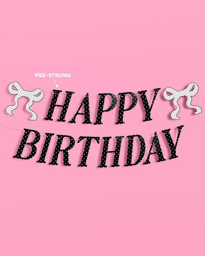 Happy Birthday banner with decorative ribbons on a pink background