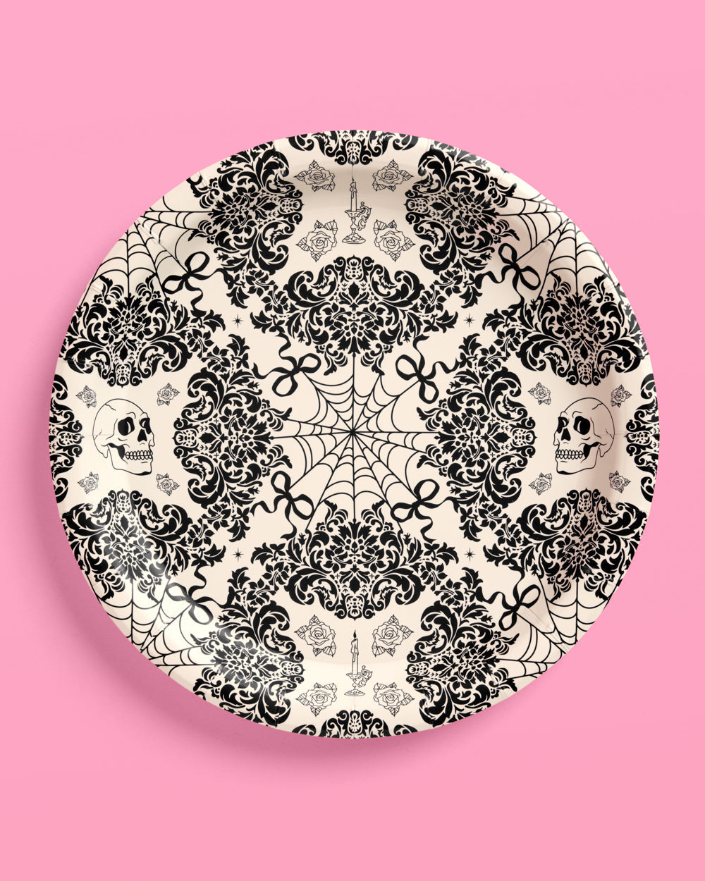 Decorative plate with black and white skull and lace pattern on a pink background